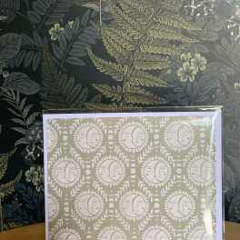 Framed botanical print with repeating moon faces on a table