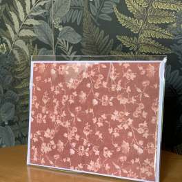 Framed pink floral print on a table