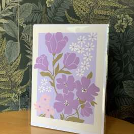 Floral greeting card with purple flowers on a lavender background
