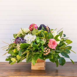 Mixed pink and white flowers in a wooden box arrangement