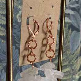 Pair of dangling earrings with rose-gold hoops and clear crystal drops