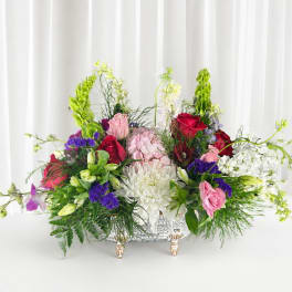 Large mixed floral arrangement in a decorative silver basket