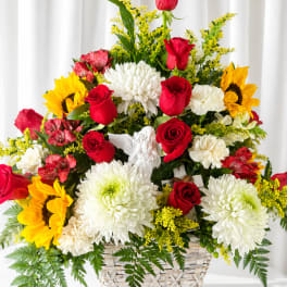 Basket arrangement of red roses, white chrysanthemums, and yellow sunflowers