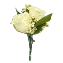 White rose boutonniere with small white accents and green leaves