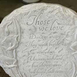 Round memorial plaque with engraved flowers and a sympathy poem