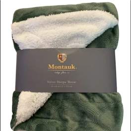 Folded green sherpa throw blanket with a gray label band