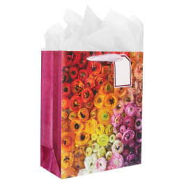 Decorative gift bag with a colorful floral print and white tissue paper