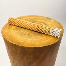 Bundle of incense sticks resting on a wooden stump