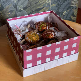 Box of wrapped chocolate candies in pink and white packaging
