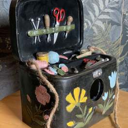 Decorative black sewing box with miniature tools and floral painted accents