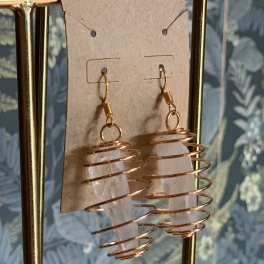 Pair of crystal point earrings wrapped in copper wire on a display card