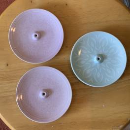 Three pastel plastic floral discs on a wooden table