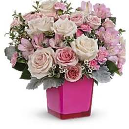 Pink and white roses arranged in a bright pink vase