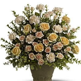 Arrangement of cream and blush roses in a textured vase
