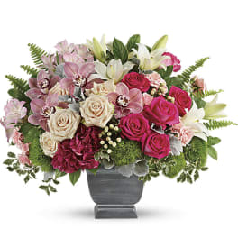 Pink and white floral arrangement in a gray urn vase