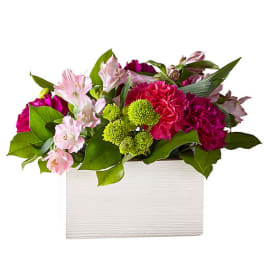 Pink and green floral arrangement in a white rectangular box