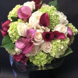 Bouquet of pink calla lilies, cream roses, and green hydrangeas