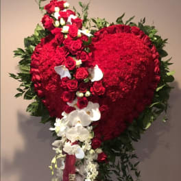 Heart-shaped red floral standing arrangement with white orchids and roses
