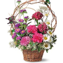 Basket arrangement of pink and purple flowers with white daisies
