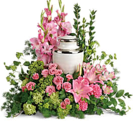 Pink floral arrangement around a silver urn