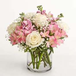 Pink and white bouquet of roses and alstroemeria in a clear glass vase