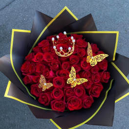 Bouquet of red roses with gold butterfly decorations and black wrapping