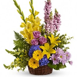 Basket arrangement with yellow lilies, purple roses, and lavender flowers