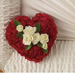 Heart-shaped red rose arrangement with white roses and green leaves