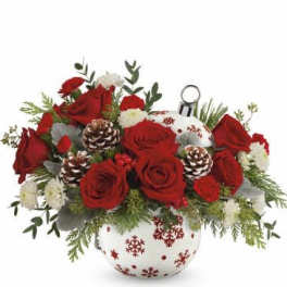 Red roses and white carnations in a snowflake vase with pinecones