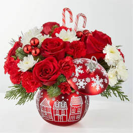 Red roses and white daisies with candy cane picks in a holiday ornament container