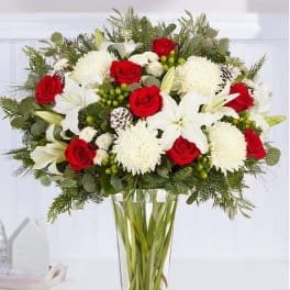 Red roses and white lilies in a clear glass vase