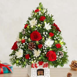 Christmas tree-shaped floral arrangement with red and white flowers in a decorative vase