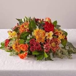 Mixed bouquet of orange, red, and yellow flowers on a white cloth