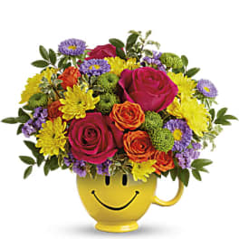 Colorful bouquet in a yellow smiley-face mug