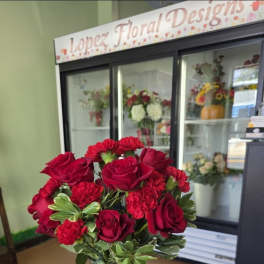 Red roses and carnations in a clear glass vase