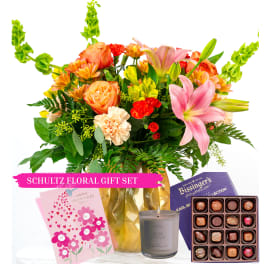 Mixed bouquet with orange roses, pink lilies, and carnations with card, candle, and chocolates.