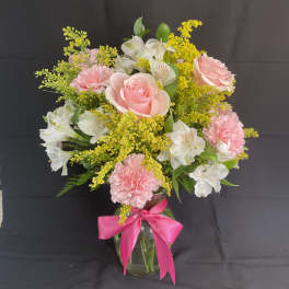 Pink roses and carnations with white alstroemeria in a glass vase