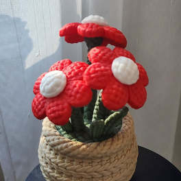 Red and white mushroom-shaped floral sculpture in a woven basket