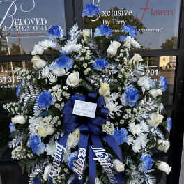 Large blue and white funeral wreath with roses and carnations