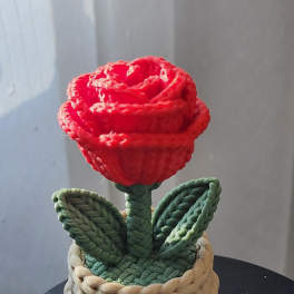 Red rose-shaped decorative piece in a woven basket planter