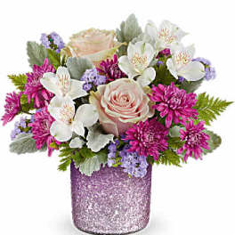 Pink and white flower arrangement in a glittery purple vase