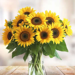 Bouquet of yellow sunflowers in a clear glass vase