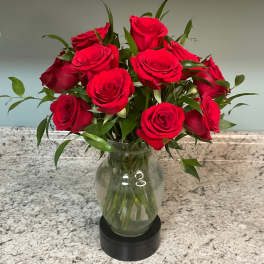 Red roses arranged in a clear glass vase