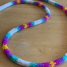 Colorful beaded necklace laid on a wooden surface