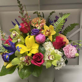Bright mixed bouquet in a round hatbox with roses, orchids, lilies, and hydrangea