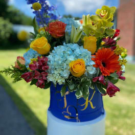 Colorful mixed bouquet in a blue container outdoors