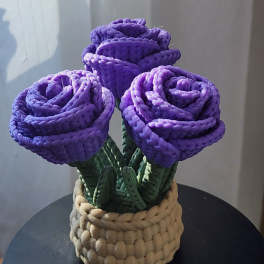 Three purple roses in a woven basket