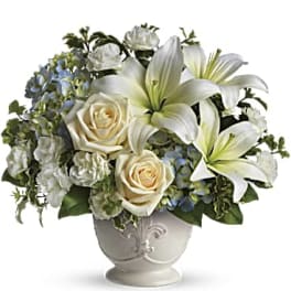 White lilies and cream roses arranged in a decorative vase