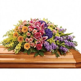 Colorful floral spray on a wooden casket