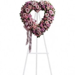 Heart-shaped pink rose wreath on a white easel